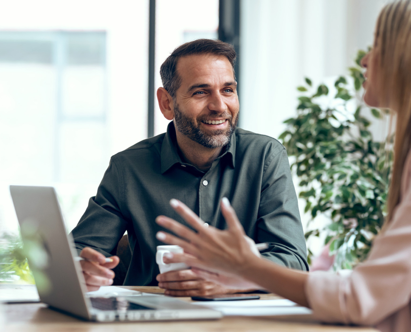 Two Business People In Office Talking At Computer